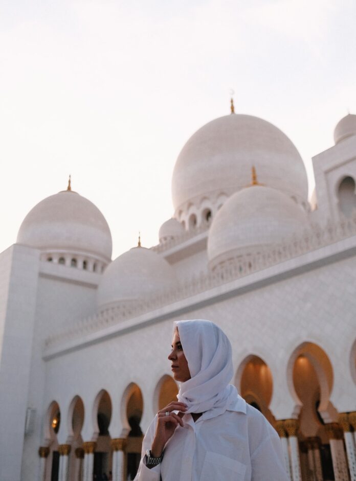 Une femme voilée devant une mosquée